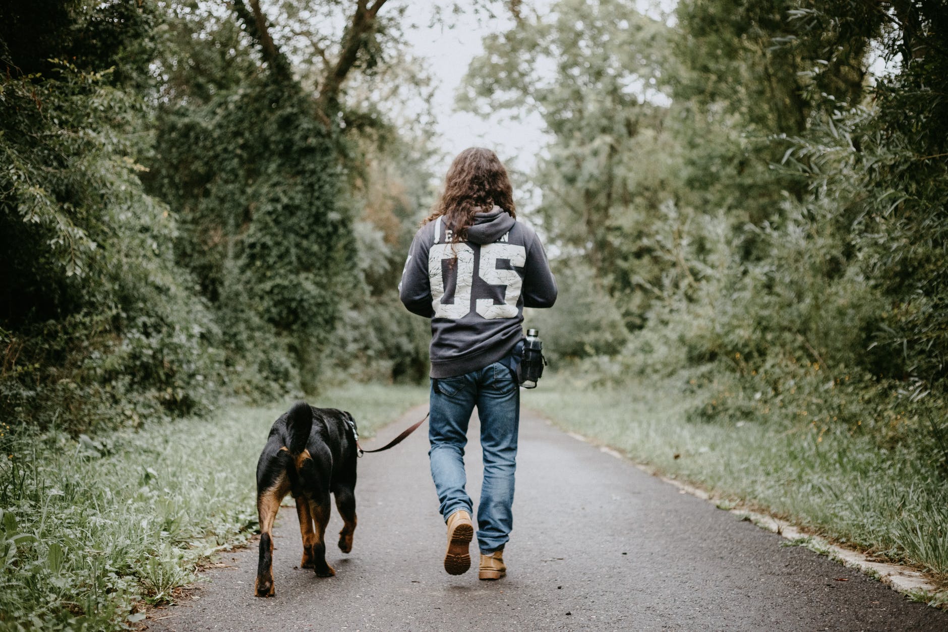 man holdingwalking dog